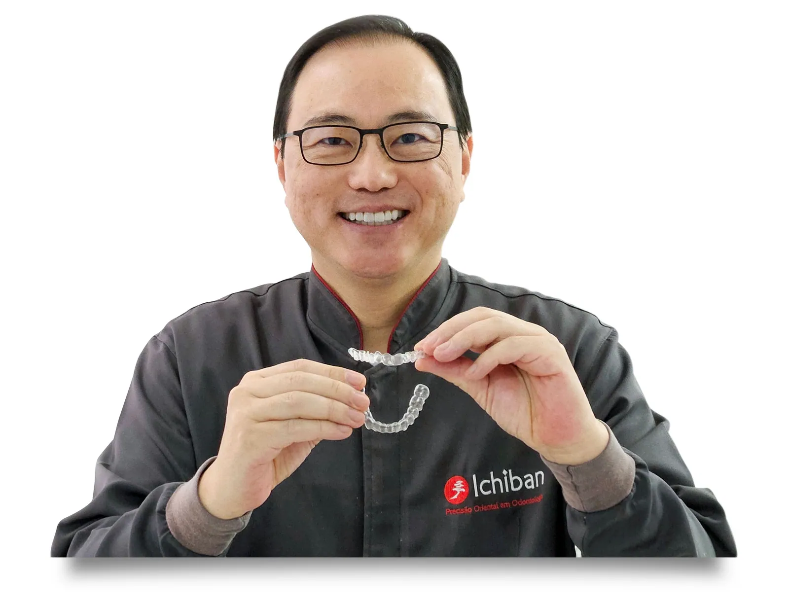 Dr. Rinaldo Ymagawa segurando um alinhador Invisalign