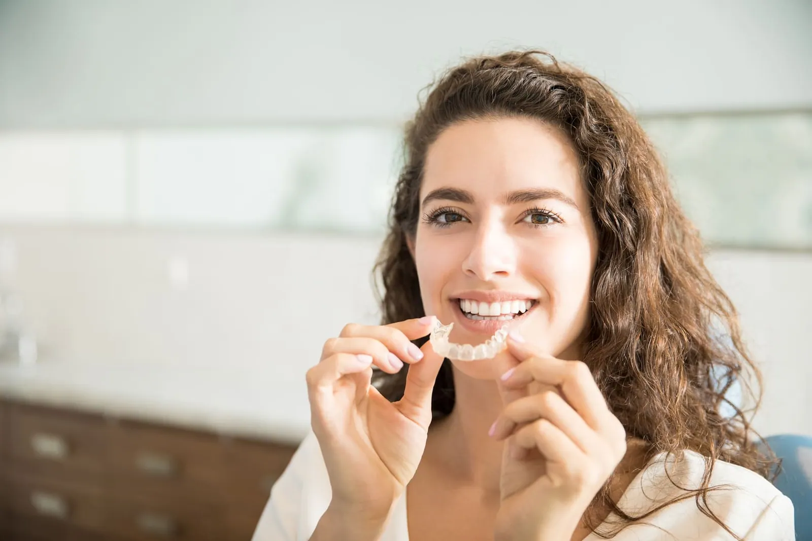 Paciente colocando alinhador transparente Invisalign