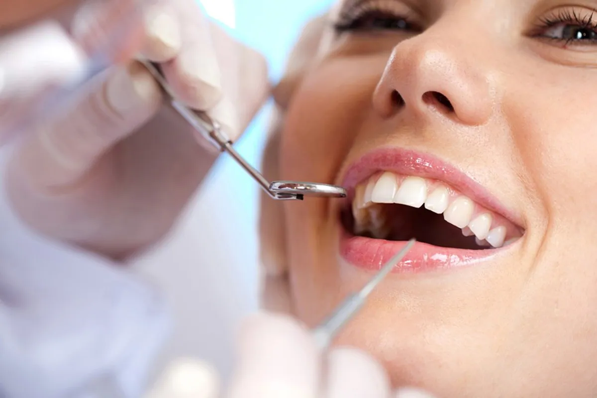 Dentista examinando a gengiva de uma paciente